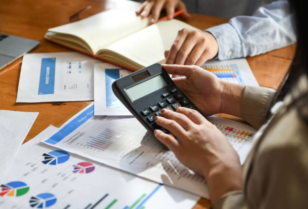 The accounting team is using the calculator in the office.